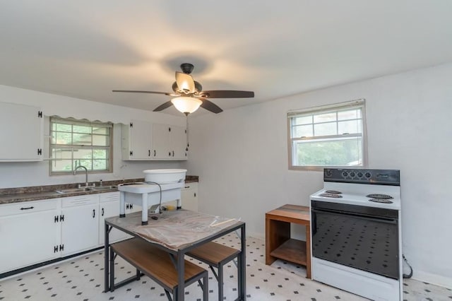 kitchen with plenty of natural light, sink, white cabinetry, and white electric stove