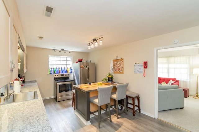 kitchen featuring a kitchen bar, stainless steel appliances, butcher block countertops, and dark hardwood / wood-style floors