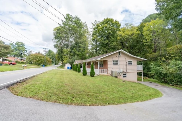 view of side of property with a lawn, a porch, and cooling unit