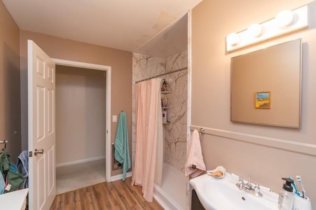 bathroom with hardwood / wood-style floors, vanity, and walk in shower