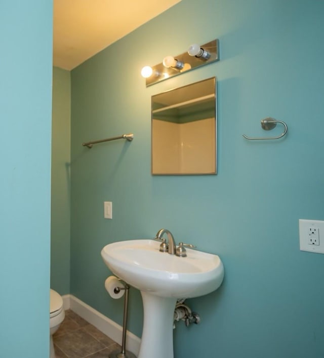 bathroom featuring tile patterned flooring, toilet, and sink