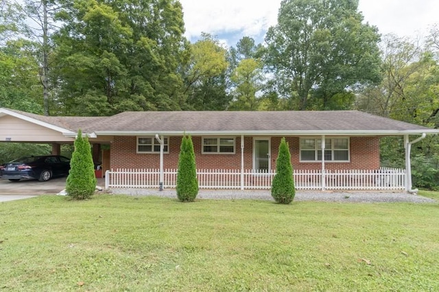 ranch-style home featuring a front yard, a carport, and covered porch