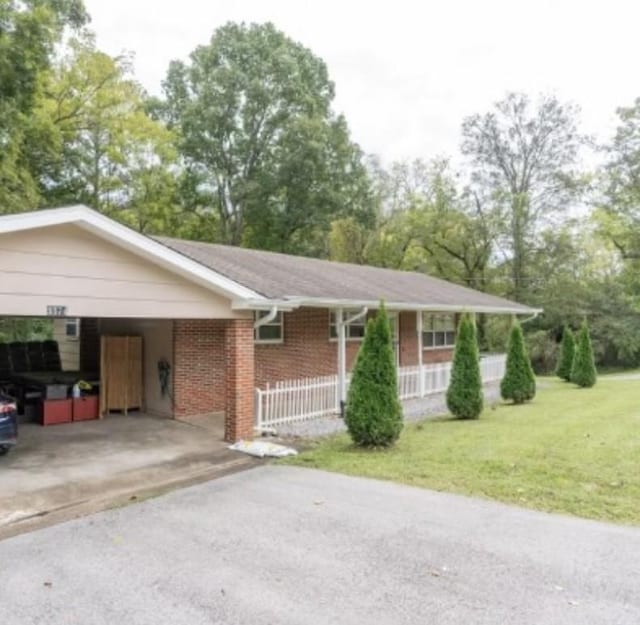 single story home with a front lawn and a carport