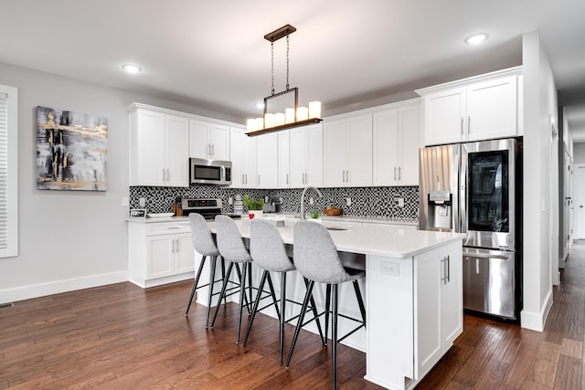 kitchen featuring white cabinets, appliances with stainless steel finishes, and dark hardwood / wood-style floors