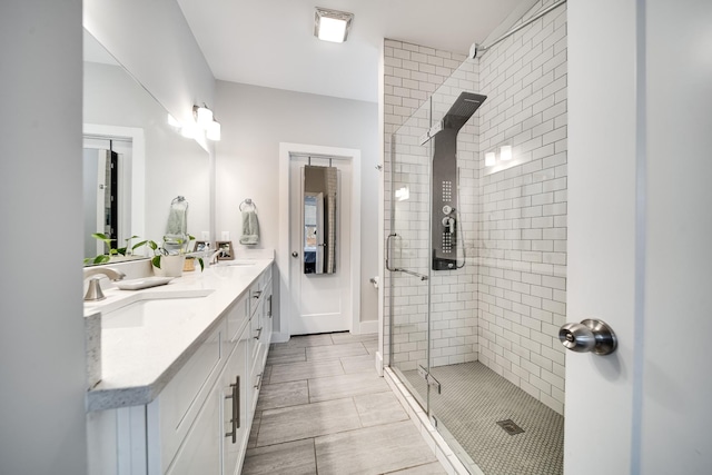 bathroom with tile patterned floors, vanity, and a shower with door