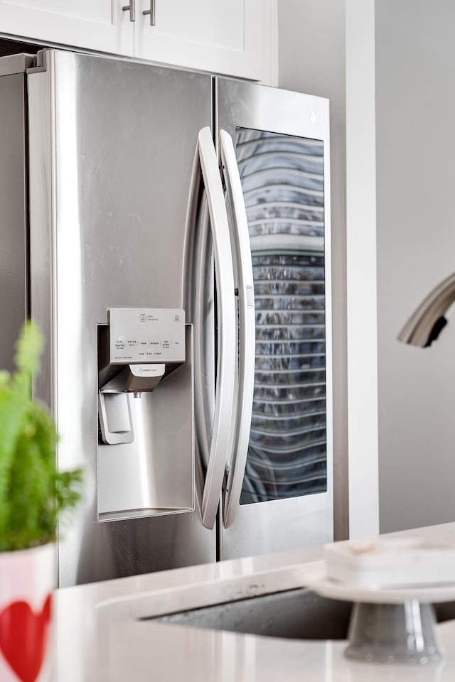 interior details featuring white cabinets and stainless steel refrigerator with ice dispenser