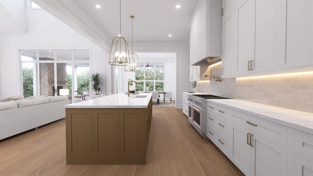 kitchen featuring premium range hood, pendant lighting, high end stove, white cabinetry, and light stone counters