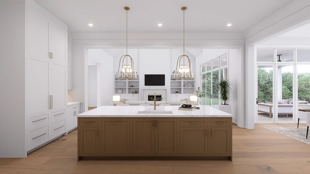 kitchen with pendant lighting, white cabinetry, a spacious island, a notable chandelier, and light hardwood / wood-style floors