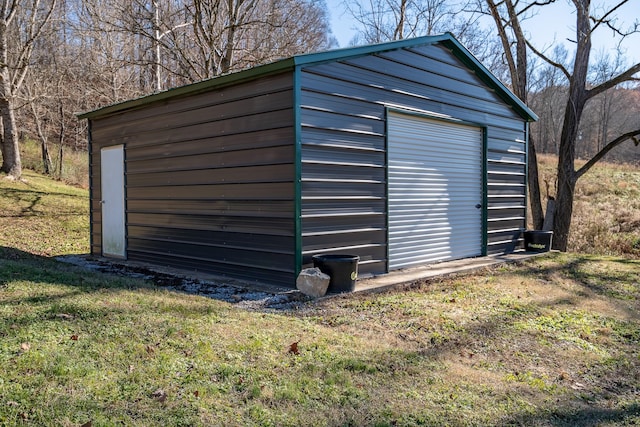 view of outdoor structure featuring a garage and a lawn