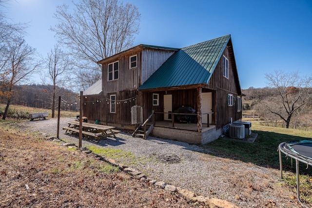 back of house featuring cooling unit and a trampoline