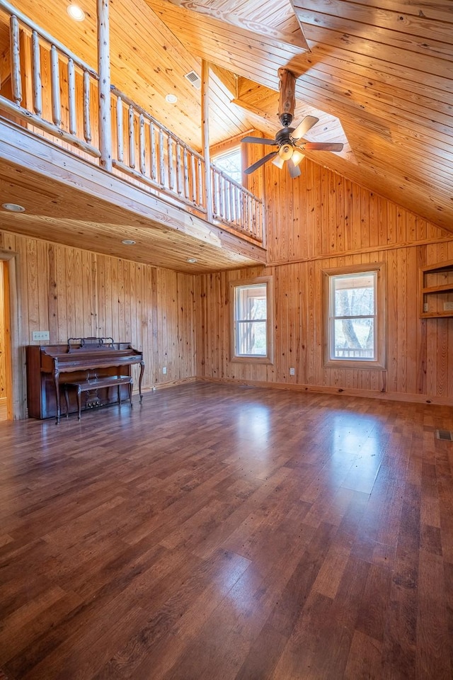 unfurnished living room with high vaulted ceiling, dark wood-type flooring, wooden ceiling, and ceiling fan