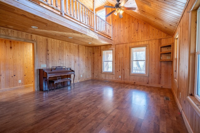 interior space featuring ceiling fan, wood-type flooring, wood walls, and wooden ceiling