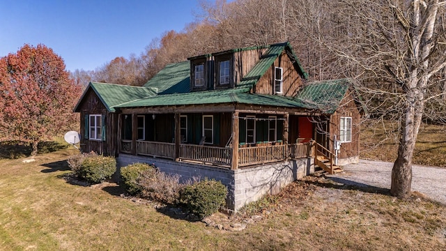 view of side of home with a lawn and a porch