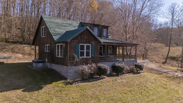 exterior space featuring covered porch and a lawn