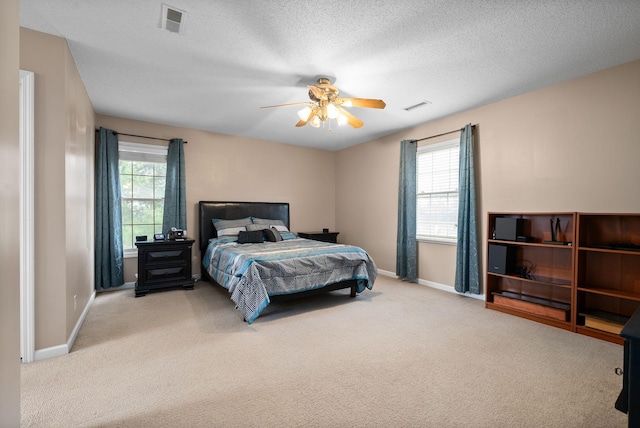 carpeted bedroom with a textured ceiling and ceiling fan