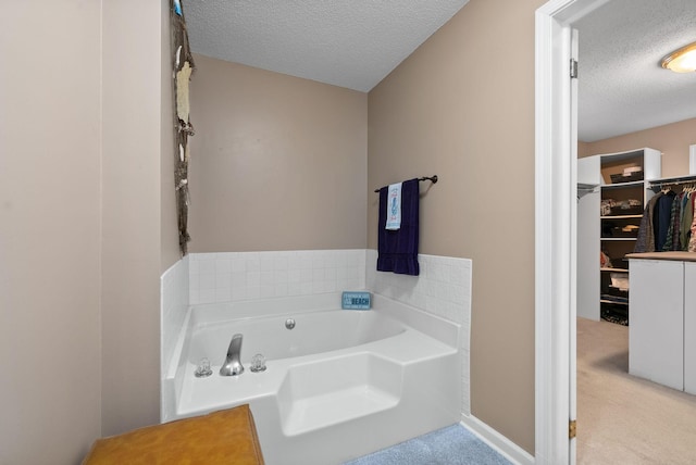 bathroom with a textured ceiling and a tub