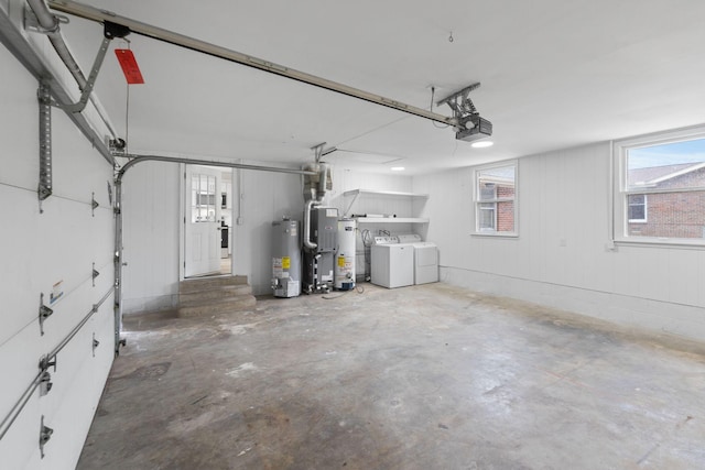 garage with a garage door opener, washer and clothes dryer, and water heater