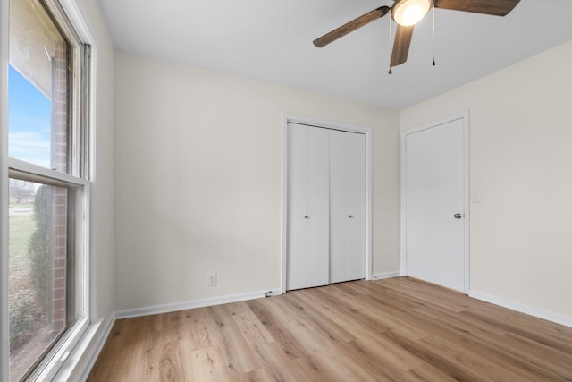 unfurnished bedroom featuring ceiling fan, light wood-type flooring, and a closet