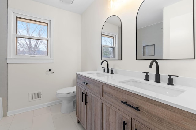 bathroom featuring tile patterned flooring, vanity, toilet, and a healthy amount of sunlight