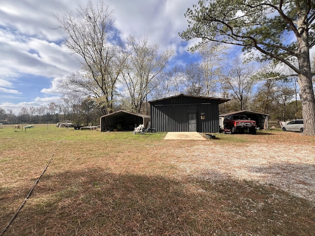 619 N Diagonal St, Decherd, TN 37324 - view of grassy yard with a detached carport, dirt driveway, and an outbuilding
