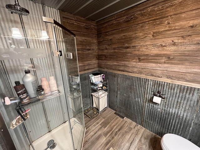 bathroom featuring wood walls, toilet, and wood-type flooring