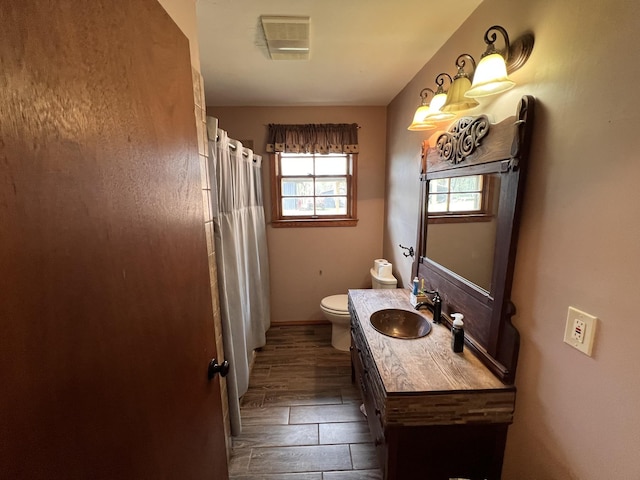 bathroom with a shower with shower curtain, vanity, wood-type flooring, and toilet