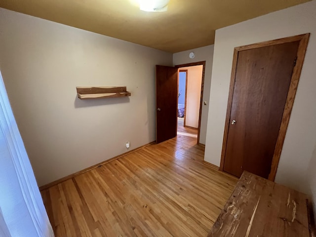 unfurnished bedroom with light wood-type flooring and a closet