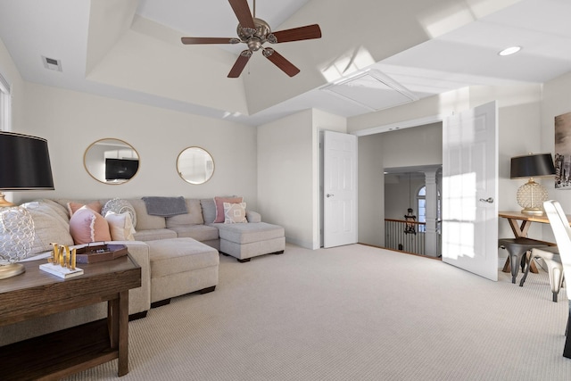 living room featuring ceiling fan, a tray ceiling, and carpet flooring