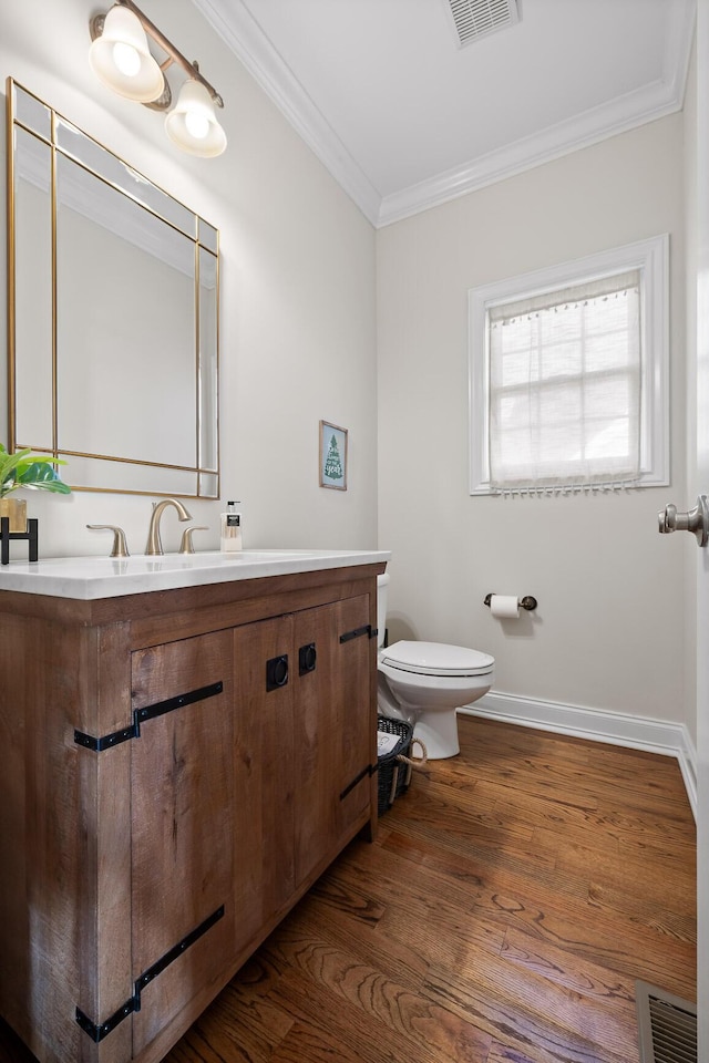 bathroom featuring ornamental molding, hardwood / wood-style flooring, toilet, and vanity