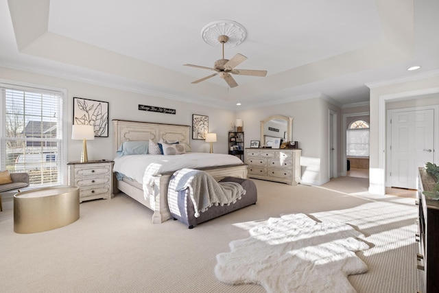 bedroom featuring ceiling fan, a tray ceiling, carpet floors, and crown molding