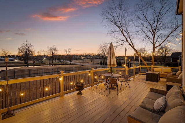 deck at dusk featuring outdoor lounge area