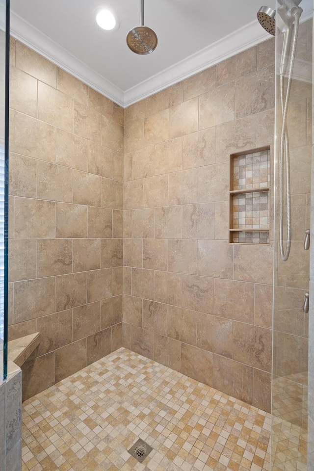 bathroom featuring tiled shower and crown molding