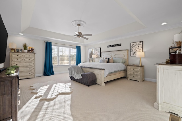 bedroom with ceiling fan, light colored carpet, ornamental molding, and a raised ceiling