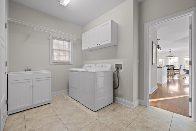 laundry area featuring cabinets, washer and clothes dryer, sink, and light tile patterned flooring