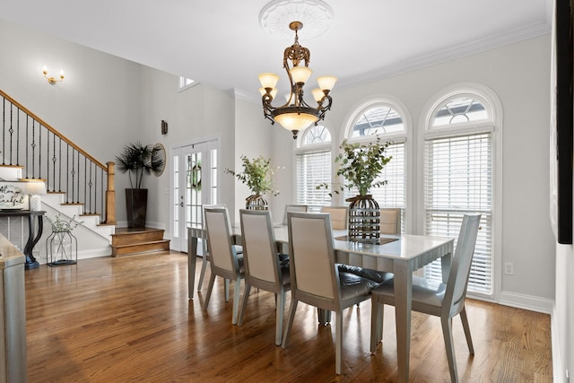 dining room featuring a notable chandelier, hardwood / wood-style floors, and crown molding