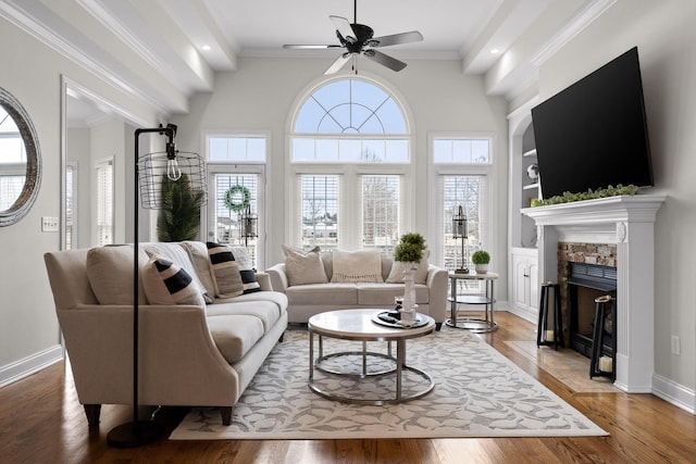 living room featuring wood-type flooring, ceiling fan, and ornamental molding