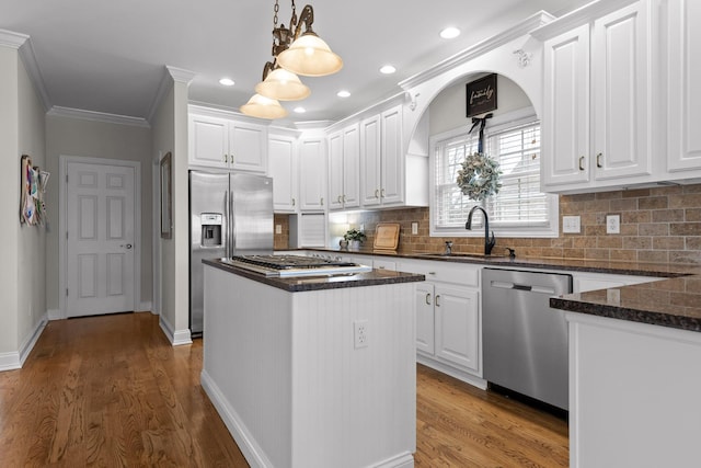 kitchen with a center island, hanging light fixtures, sink, white cabinets, and stainless steel appliances