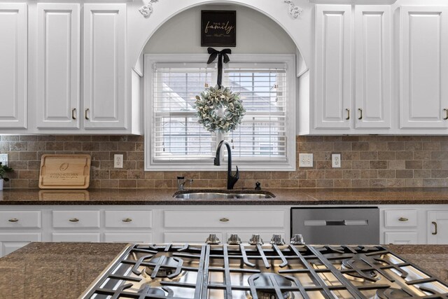 kitchen featuring sink, dark stone counters, white cabinets, and appliances with stainless steel finishes