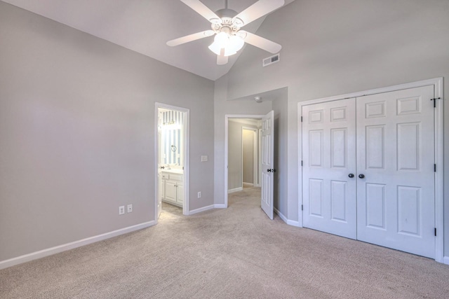 unfurnished bedroom with light colored carpet, a closet, lofted ceiling, and ceiling fan