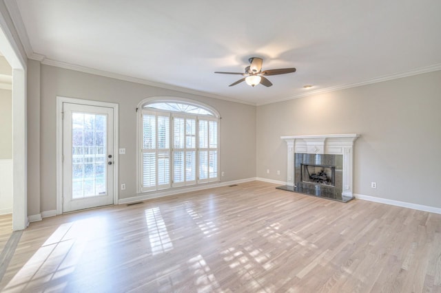 unfurnished living room featuring crown molding, a fireplace, ceiling fan, and light wood-type flooring