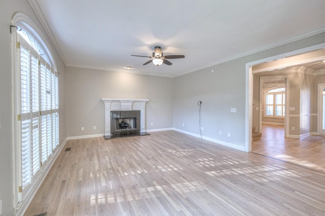 unfurnished living room with ceiling fan, light hardwood / wood-style floors, crown molding, and a fireplace