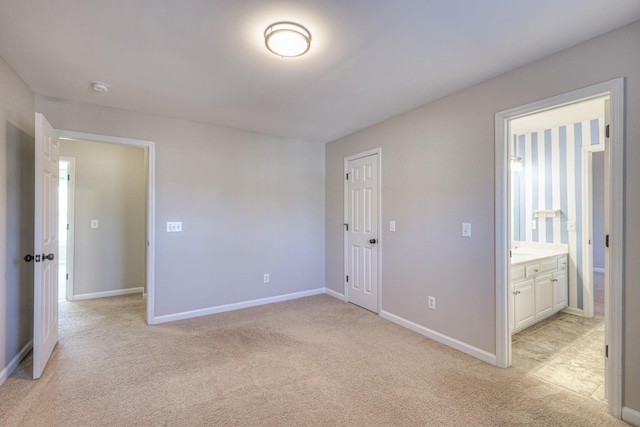 unfurnished bedroom featuring connected bathroom, light carpet, and a closet