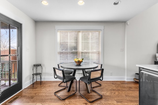 dining room featuring hardwood / wood-style flooring, a healthy amount of sunlight, and beverage cooler