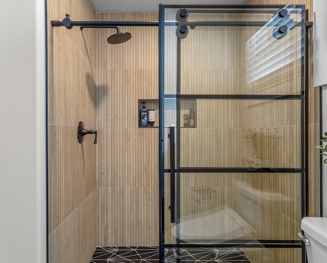 bathroom featuring toilet and a tile shower