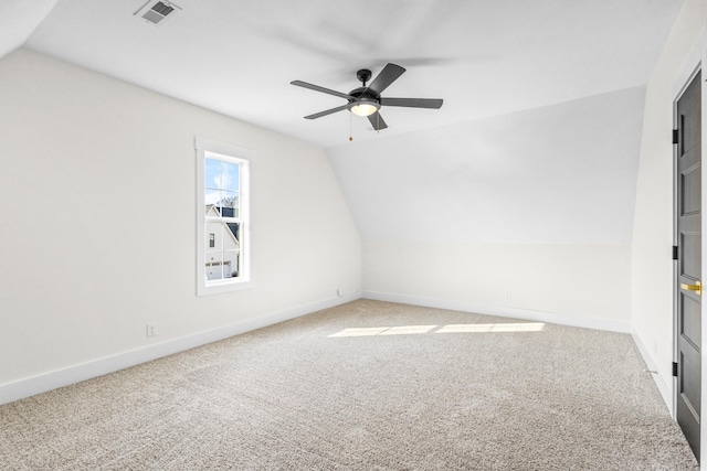 carpeted spare room featuring ceiling fan and lofted ceiling