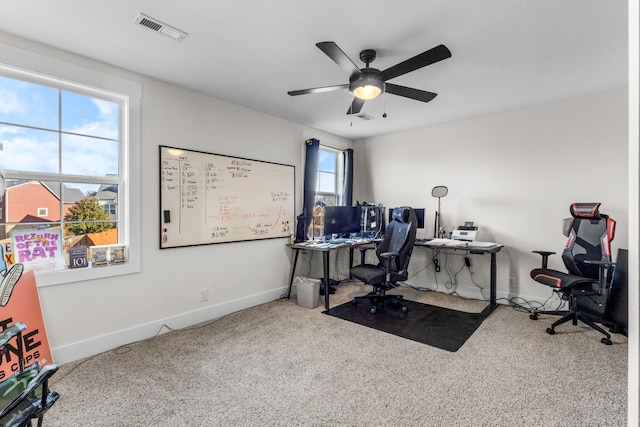 carpeted office featuring ceiling fan and a healthy amount of sunlight