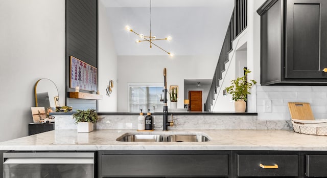 kitchen with light stone countertops, tasteful backsplash, sink, a notable chandelier, and wine cooler