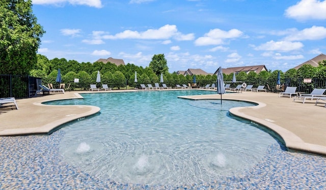 view of swimming pool with pool water feature and a patio