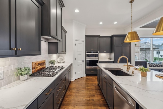 kitchen with appliances with stainless steel finishes, tasteful backsplash, sink, dark hardwood / wood-style floors, and hanging light fixtures