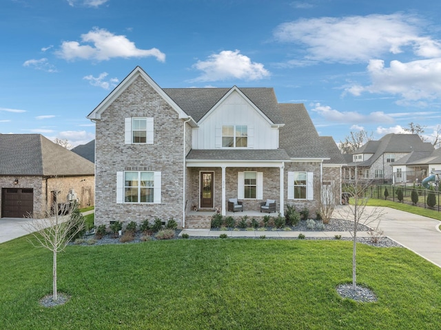 view of front of property with a porch, a garage, and a front lawn